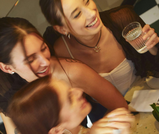 A group of women sitting around a table having fun