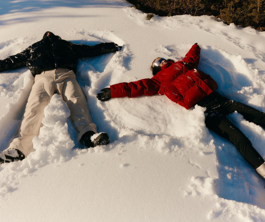 Two people lying in the snow