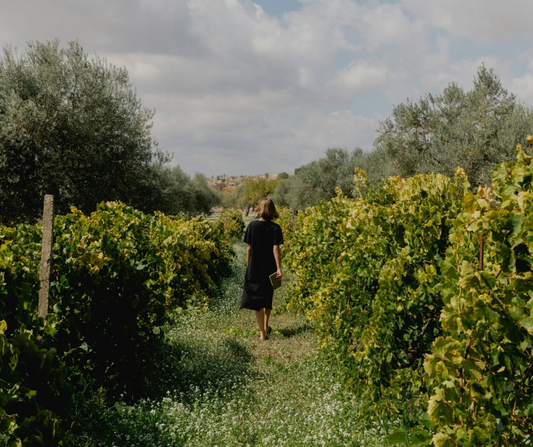 Woman walking in a lush field with hedges on both sides