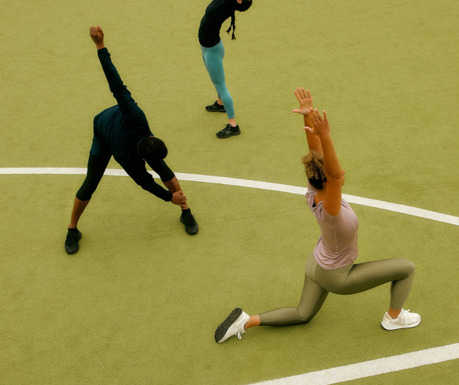 Women in gym wear stretching on track field