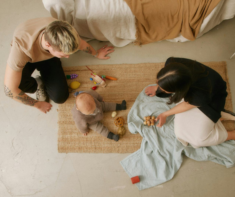 Mother and friend playing with a baby on the floor