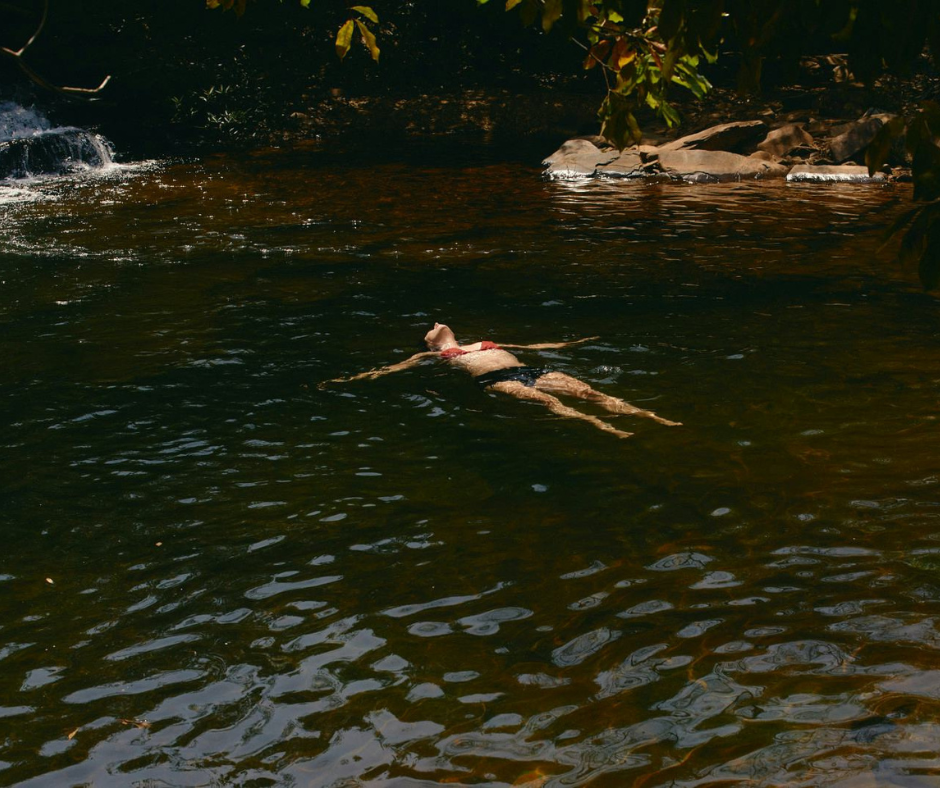 Woman relaxing face up in a natural pool