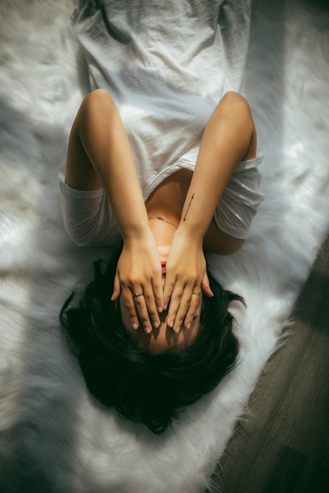 Woman grasping head in bed