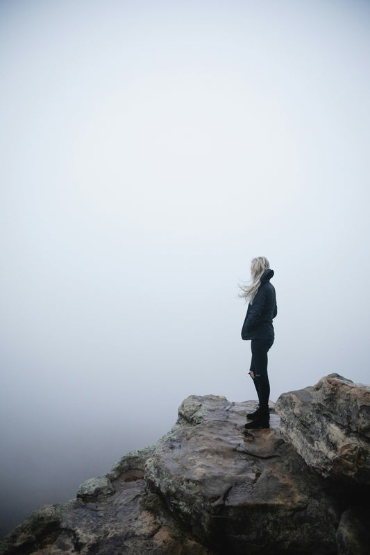 Woman standing on a rock in misty conditions